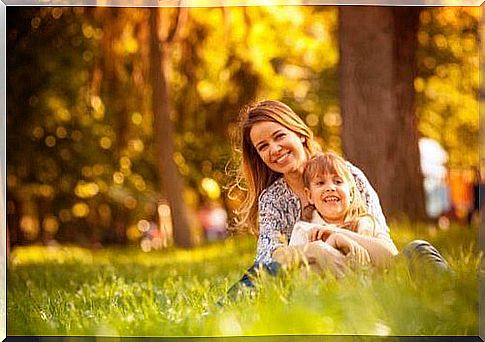 Mother is sitting with child in the park.